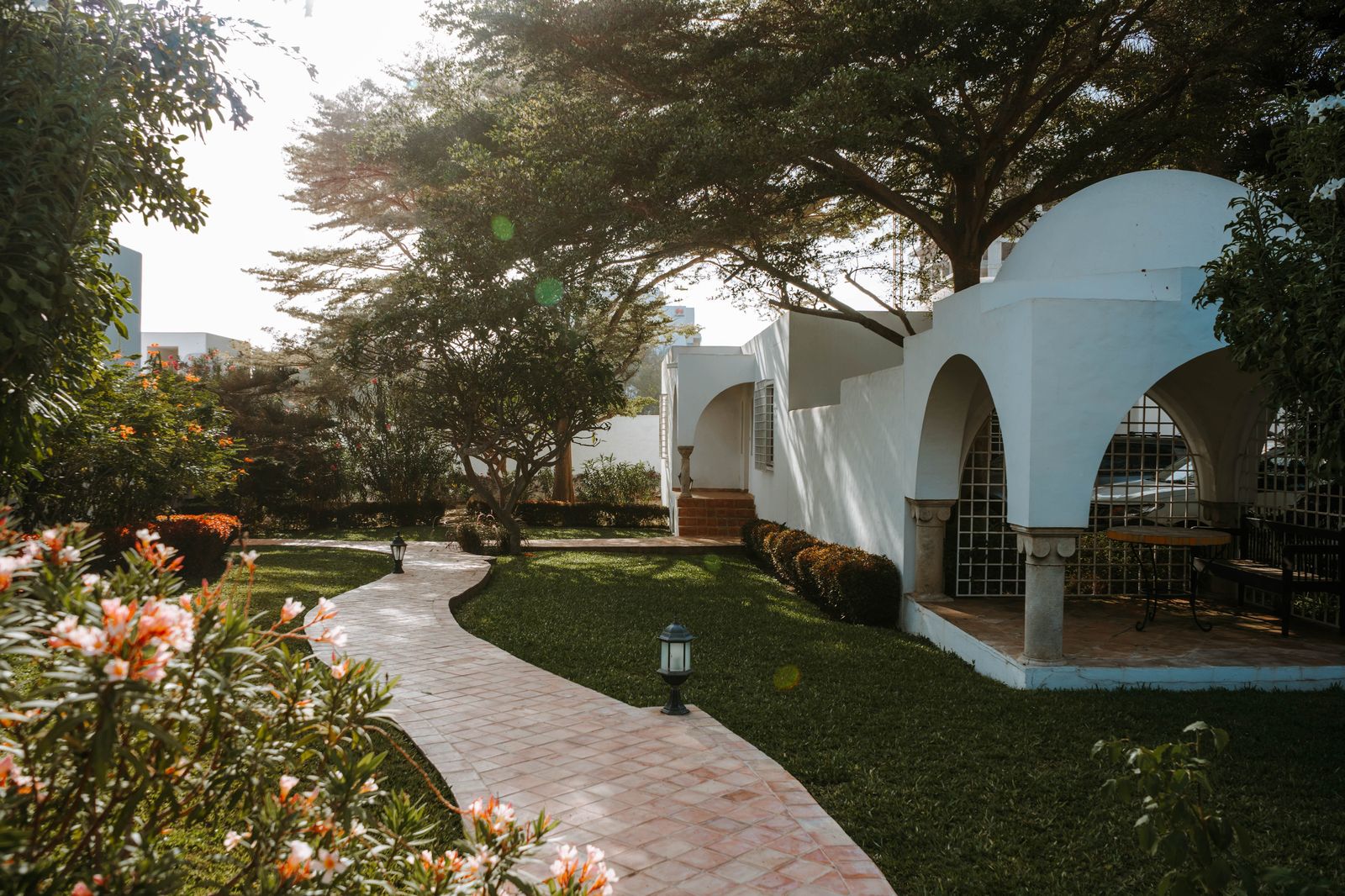 Garden pathway through the villa grounds, lined with flowers and white Moorish arches