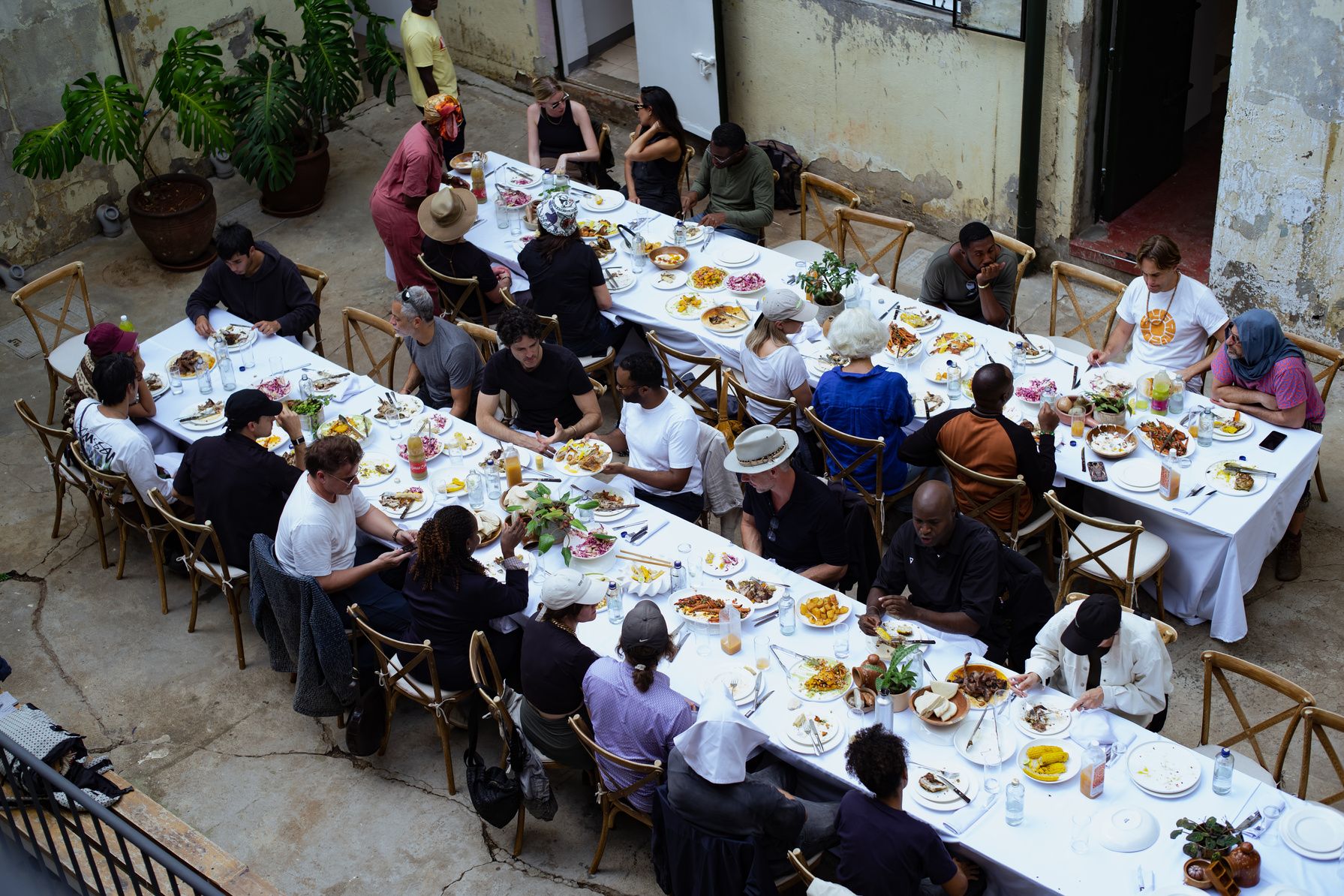Aerial view of a long communal dining table with guests from around the world